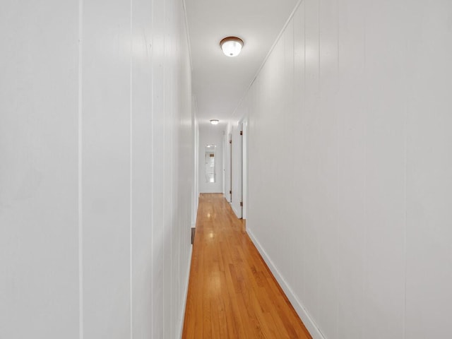 corridor featuring wood walls and light hardwood / wood-style flooring