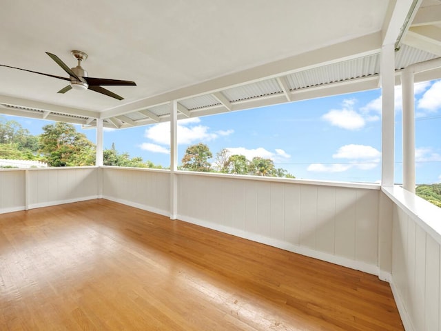 unfurnished sunroom with ceiling fan