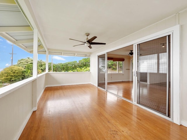 unfurnished sunroom with ceiling fan