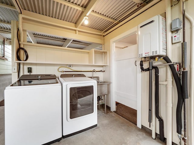 clothes washing area with washing machine and dryer and water heater