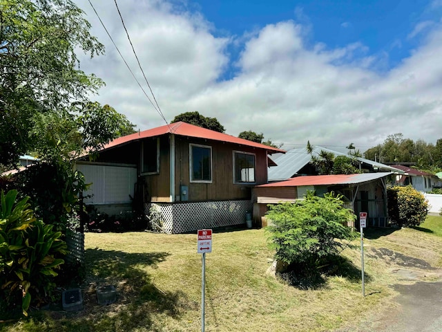 view of front of home with a front yard and solar panels