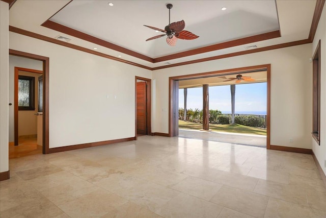 unfurnished room featuring a raised ceiling, ceiling fan, and ornamental molding