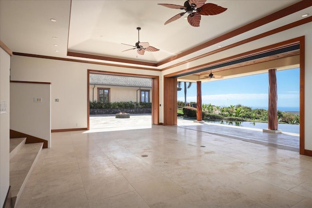 spare room with a water view, a raised ceiling, ceiling fan, and crown molding