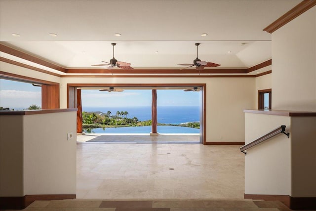 interior space with a raised ceiling, a water view, and ornamental molding