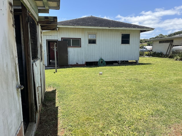 view of home's exterior with a lawn and a shingled roof