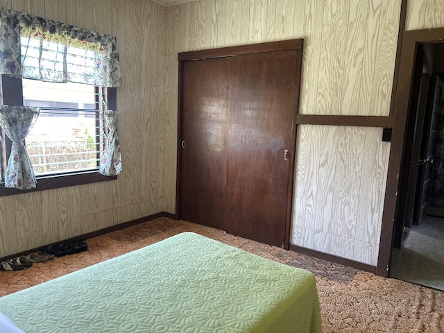 bedroom with a closet and wood walls