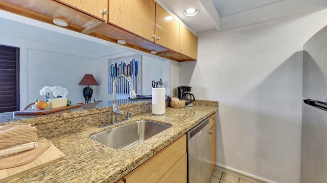 kitchen with light stone countertops, sink, light brown cabinets, light tile patterned flooring, and appliances with stainless steel finishes