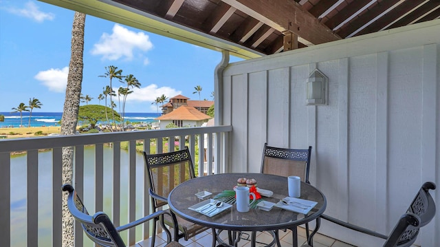 balcony featuring a beach view and a water view