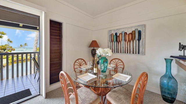 dining area with a water view and carpet floors