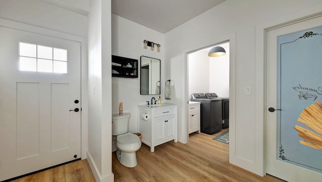 entryway with washing machine and dryer, sink, and light wood-type flooring