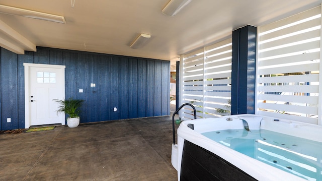 bathroom featuring concrete floors and wood walls