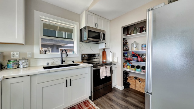 kitchen featuring white refrigerator, range with electric cooktop, white cabinetry, dark wood-type flooring, and sink