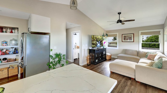 bedroom featuring dark hardwood / wood-style floors, ceiling fan, ensuite bath, lofted ceiling, and stainless steel refrigerator