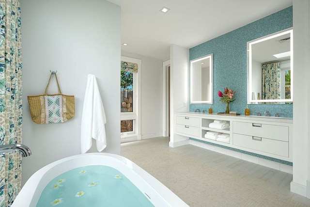 bathroom with vanity and a tub to relax in