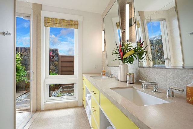 kitchen with light tile patterned flooring, white cabinetry, tasteful backsplash, and sink