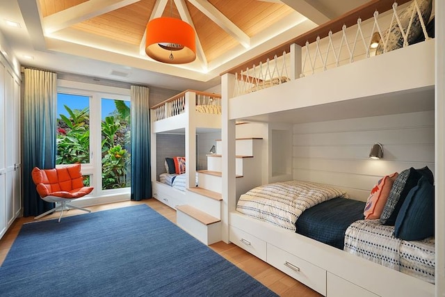 bedroom with wood-type flooring, a raised ceiling, and wood ceiling