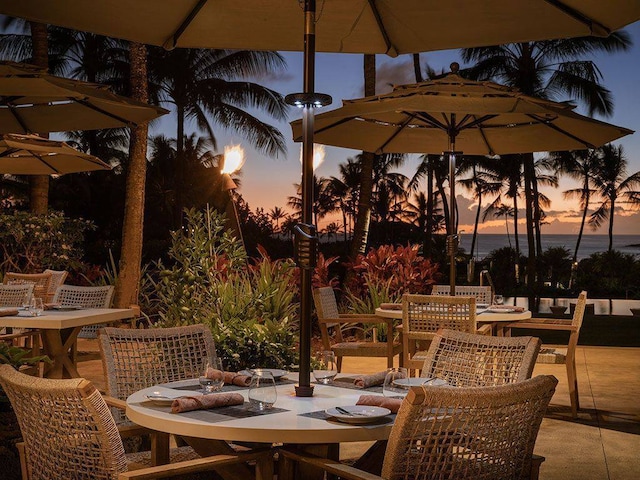 patio terrace at dusk featuring a water view