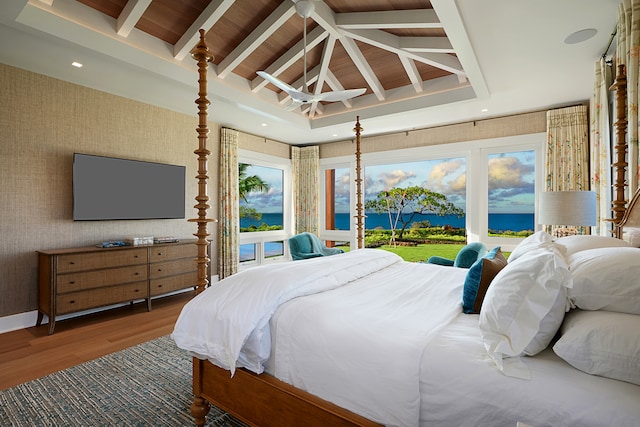 bedroom featuring vaulted ceiling with beams, access to exterior, a water view, and wood-type flooring