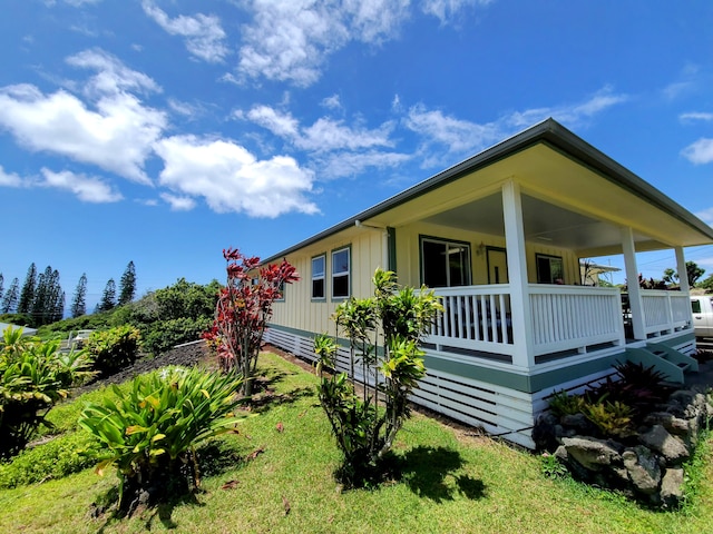 view of property exterior with a porch and a yard