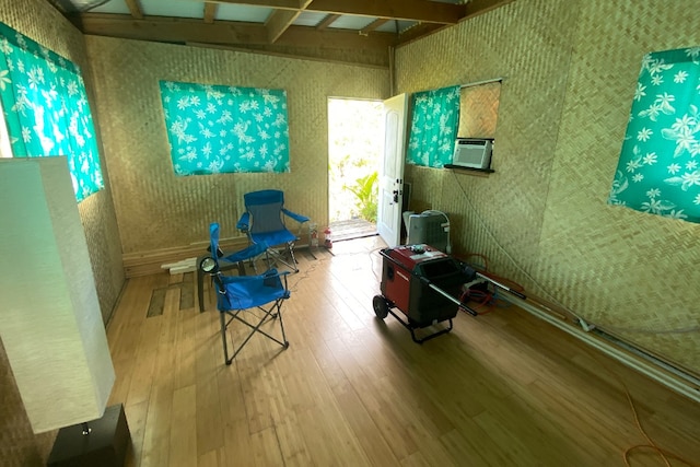 living area featuring beamed ceiling and hardwood / wood-style flooring