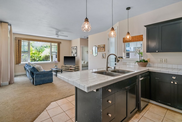 kitchen featuring pendant lighting, tile countertops, sink, ceiling fan, and light colored carpet