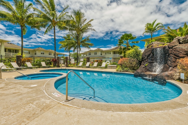 view of swimming pool with a patio area, pool water feature, and a community hot tub