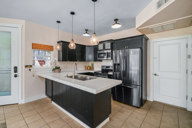 kitchen with sink, hanging light fixtures, light tile patterned flooring, kitchen peninsula, and stainless steel appliances