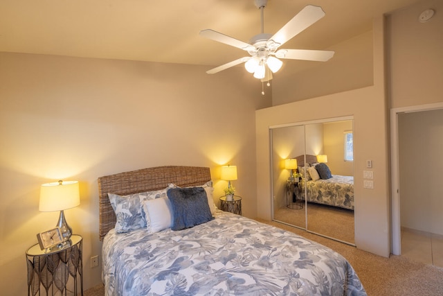 bedroom featuring ceiling fan, a closet, carpet floors, and lofted ceiling