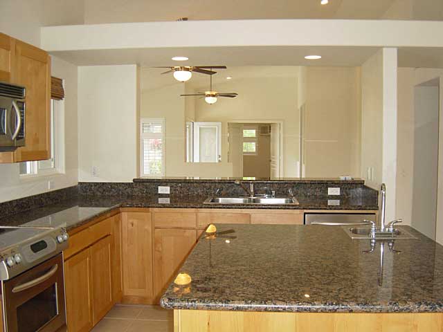 kitchen featuring sink, light tile patterned floors, dark stone counters, and appliances with stainless steel finishes