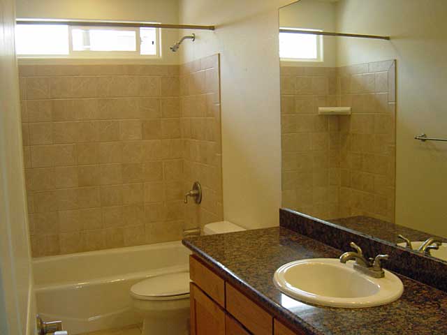 full bathroom featuring vanity, a healthy amount of sunlight, toilet, and tiled shower / bath