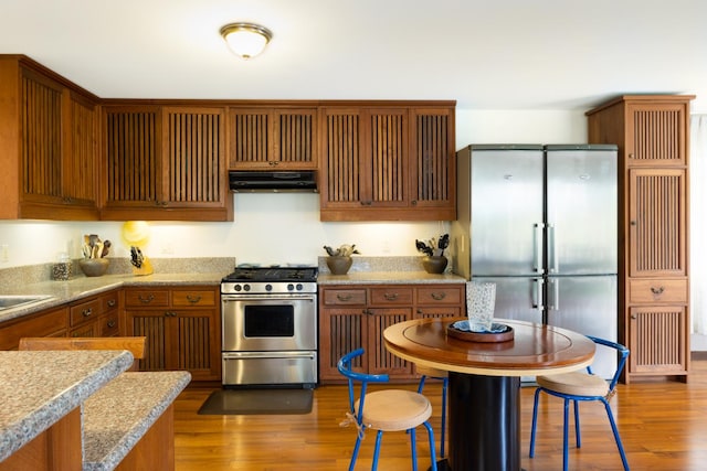 kitchen featuring hardwood / wood-style floors, stainless steel appliances, and sink