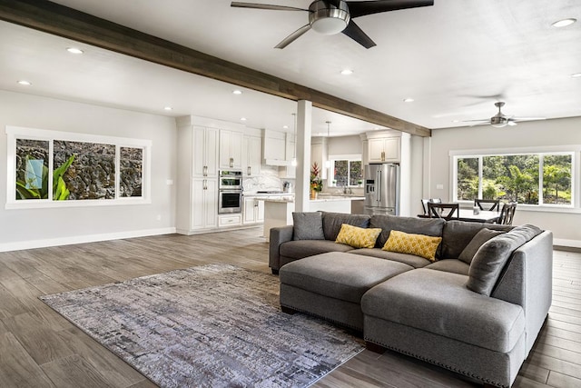 living room featuring beamed ceiling, dark hardwood / wood-style floors, and ceiling fan