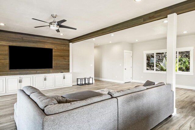 unfurnished living room featuring beam ceiling, ceiling fan, and light hardwood / wood-style flooring