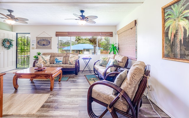 living room with ceiling fan and dark wood-type flooring