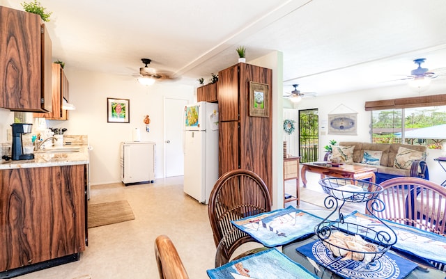 dining area with ceiling fan and sink