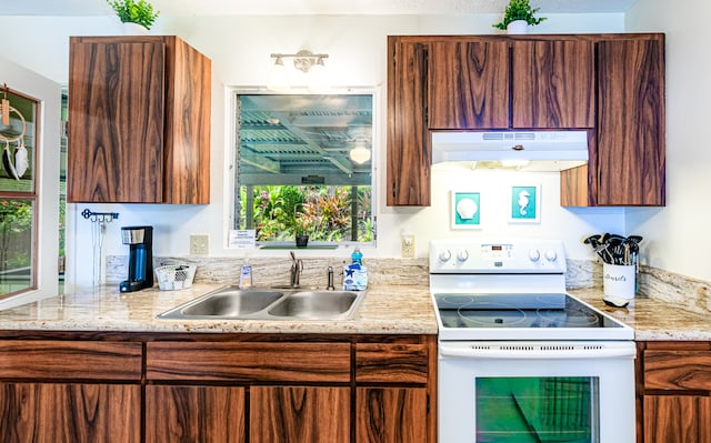 kitchen with white electric range oven, sink, and light stone countertops