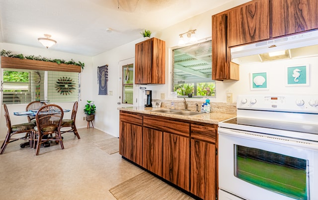 kitchen featuring sink, electric stove, and light stone counters