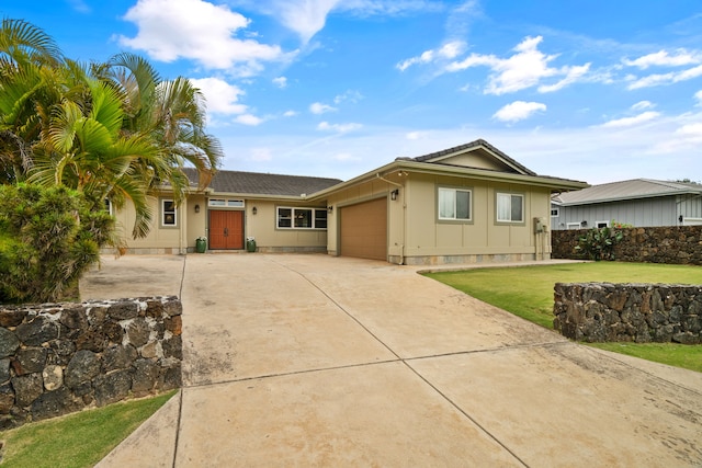 ranch-style home with a garage and a front lawn