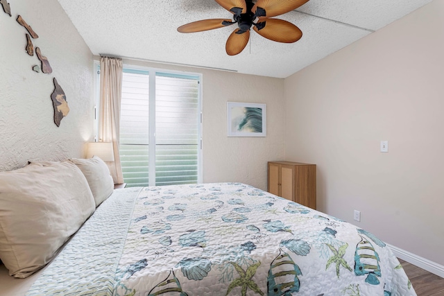 bedroom with ceiling fan, a textured ceiling, and hardwood / wood-style flooring