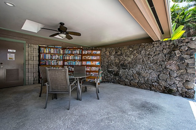 unfurnished dining area featuring ceiling fan and a skylight