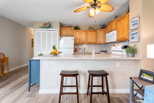 kitchen with ceiling fan, white appliances, sink, and light wood-type flooring