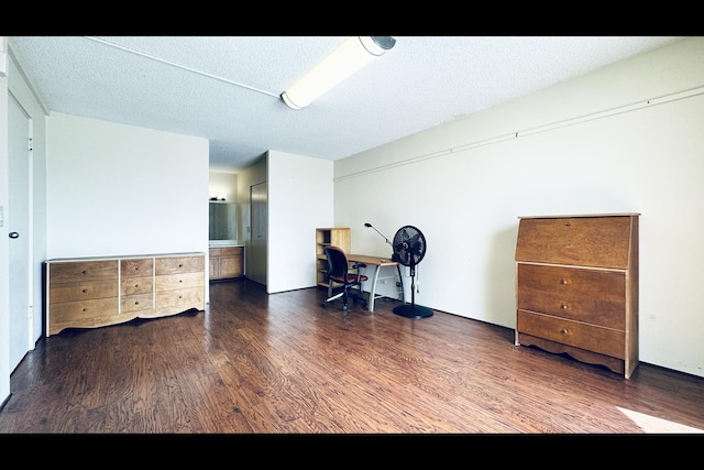 office area with dark wood-type flooring and a textured ceiling