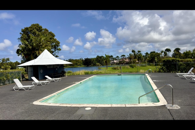 view of pool with a patio and a water view