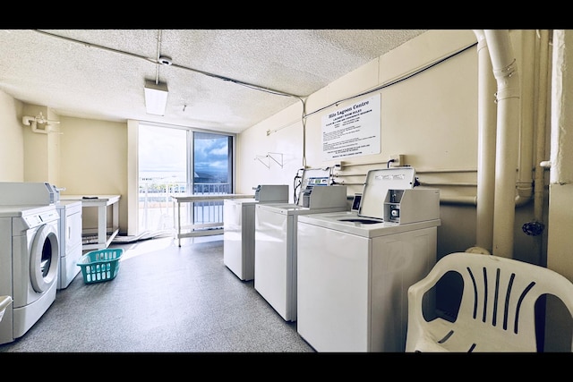 laundry room featuring washer and clothes dryer and a textured ceiling