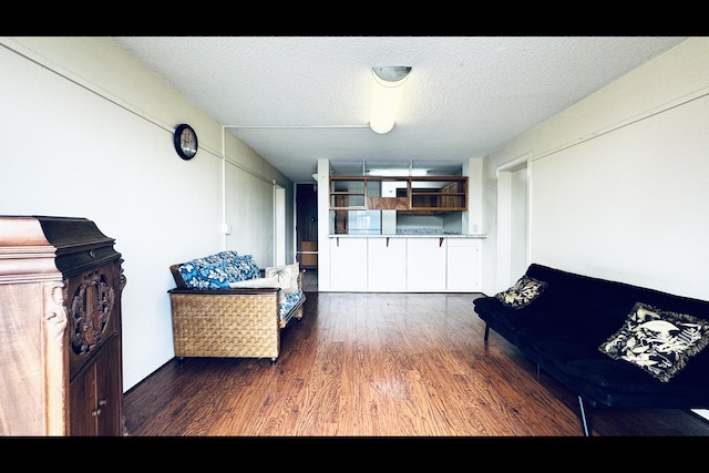 unfurnished living room featuring dark wood-type flooring and a textured ceiling