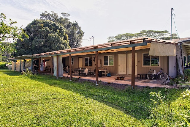 back of property featuring a lawn and a patio area