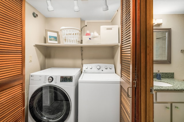 laundry area featuring washer and dryer, sink, and track lighting