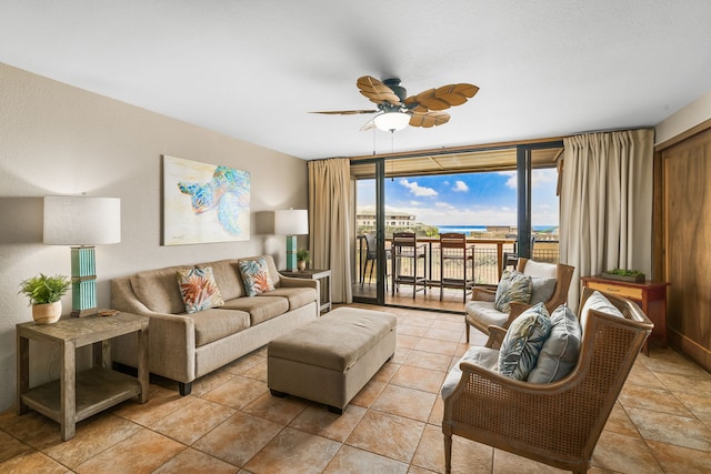 living room featuring ceiling fan and a wall of windows