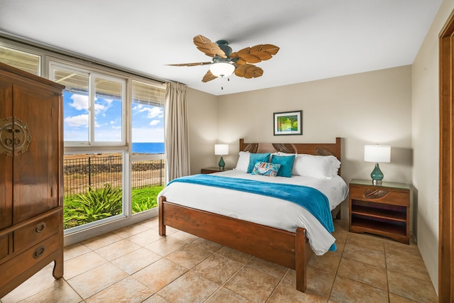 tiled bedroom featuring a water view and ceiling fan