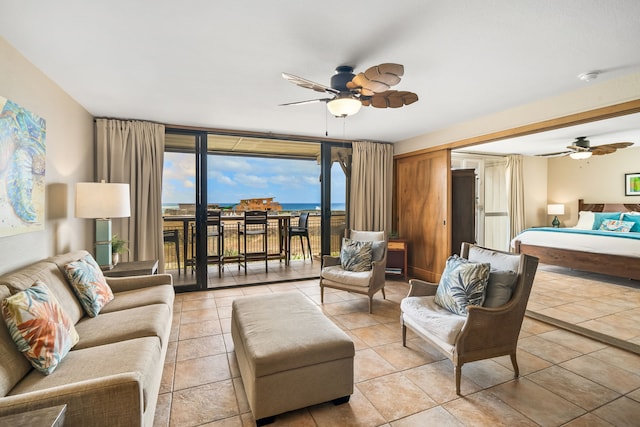 living room with ceiling fan, light tile patterned flooring, and a water view